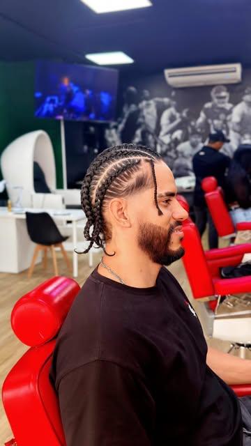 Cliente con trenzas en un sillón rojo